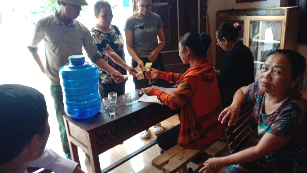 Người dân đến nhà văn hóa thôn Thượng Tứ góp tiền ủng hộ em Bùi Đình Thắng
