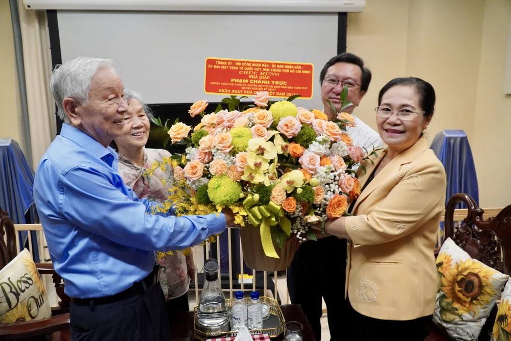 Phó Bí thư Thành ủy, Chủ tịch HĐND TPHCM Nguyễn Thị Lệ tặng hoa chúc mừng nhà giáo Phạm Chánh Trực. Ảnh: THÀNH CHUNG