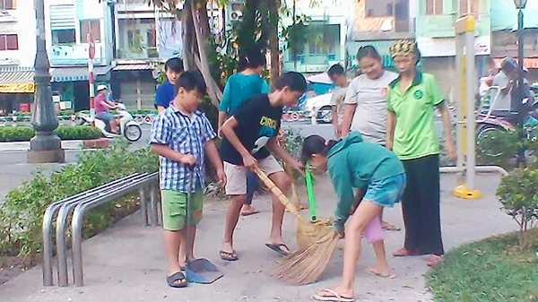 Các bé trong tổ bảo vệ Kim Đồng dọn vệ sinh trong công viên