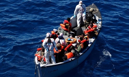Người di cư ngồi trên tàu cứu hộ trong một chiến dịch cứu nạn của hải quân Italy. Ảnh: Reuters.