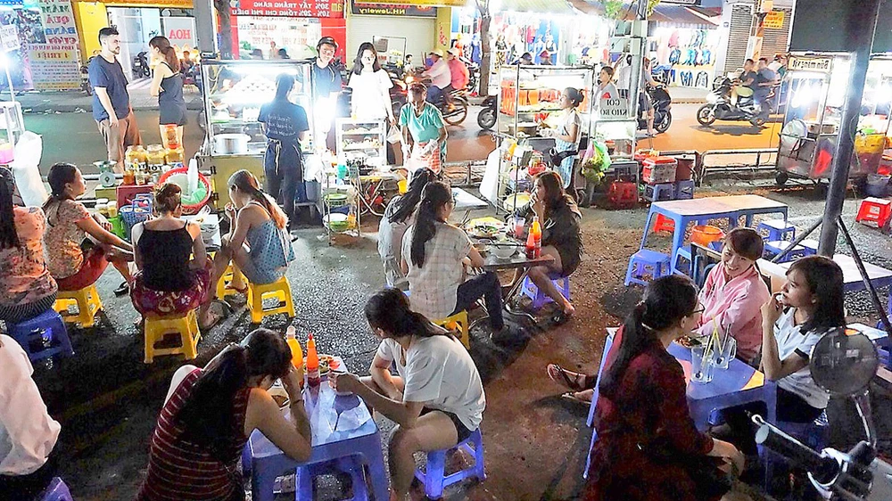 20 hộ bán hàng rong trên vỉa hè ở quận Tân Bình được bố trí bán ở chợ Phạm Văn Hai vào ban đêm Ảnh: KIỀU PHONG