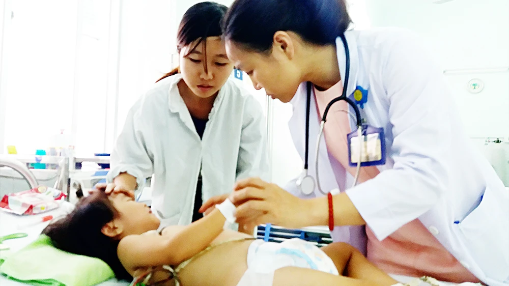 Bác sĩ Trần Thị Kim Vân khám một bệnh nhi mắc tay chân miệng
