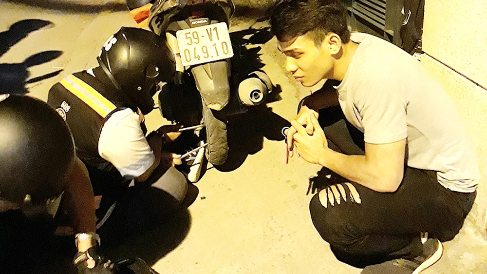 Nhóm thiện nguyện đang vá xe giúp một đôi bạn trên đường Phổ Quang (ảnh chụp lúc 22 giờ 30 tối 20-8-2017)