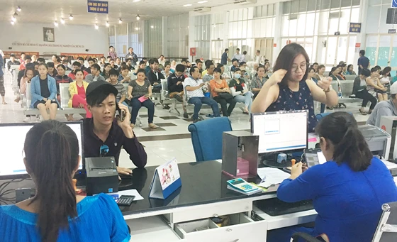 Người dân lấy số thứ tự chờ mua vé tàu Tết tại ga Sài Gòn. Ảnh: QUỐC HÙNG
