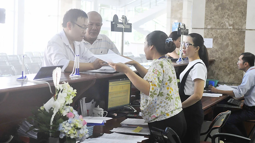 Nhân viên Cục Thuế TPHCM hướng dẫn làm hồ sơ khai thuế Ảnh: CAO THĂNG