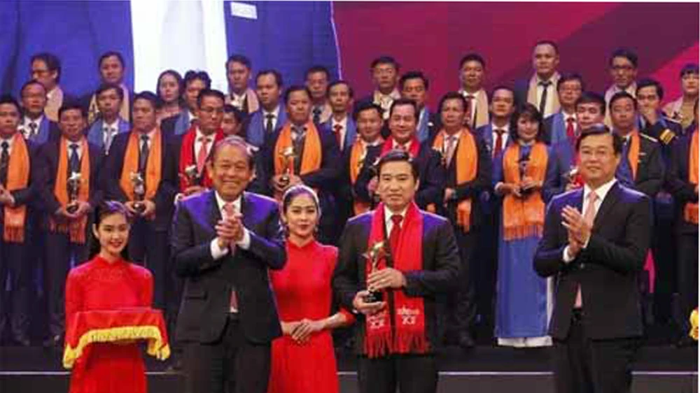 Phó Thủ tướng Thường trực Chính phủ Trương Hòa Bình và Bí thư thứ nhất Trung ương Đoàn TNCS Hồ Chí Minh trao Giải thưởng Sao Đỏ cho các Doanh nhân trẻ Việt Nam tiêu biểu năm 2017. Ảnh: TTXVN