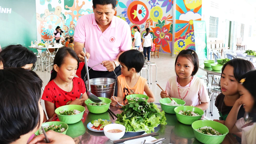 Các em nhỏ ở Cô nhi viện Thiên Bình (Đồng Nai) dùng bữa cơm có thịt do tình nguyện viên nấu