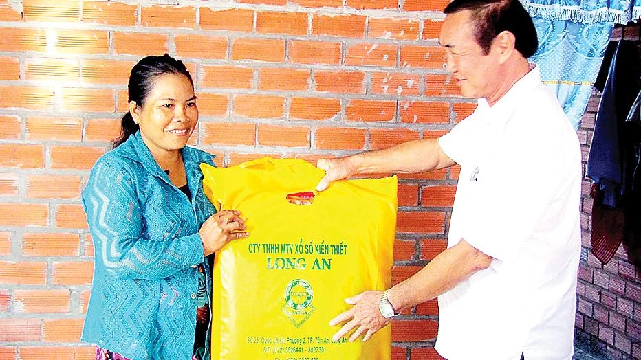Đại diện nhà tài trợ, Công ty Xổ số Kiến thiết Long An  tặng quà cho bà Trần Thị Bích Hạnh