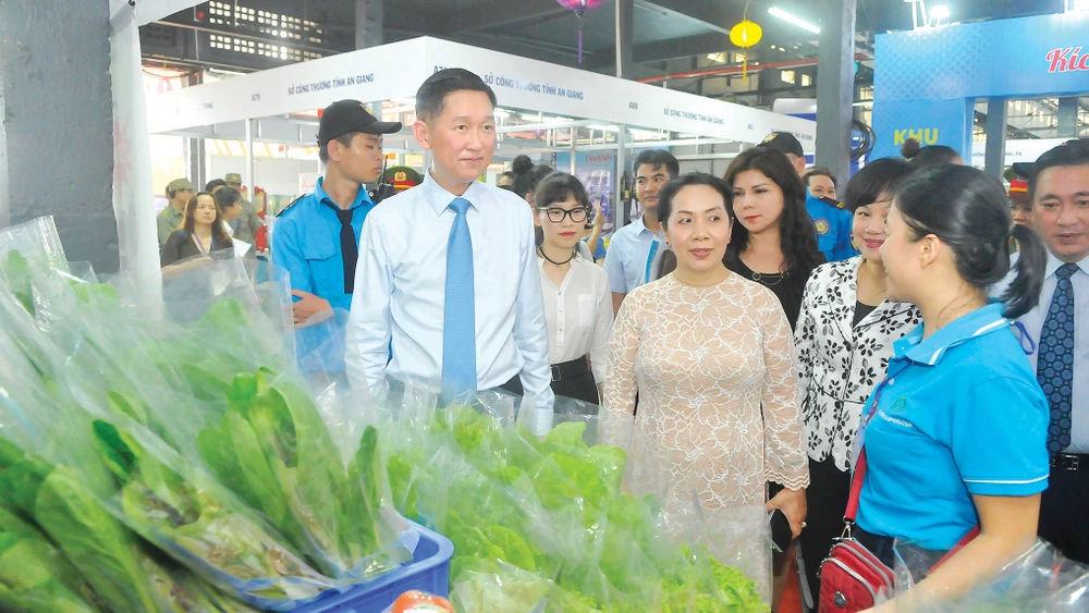 Phó Chủ tịch UBND TPHCM Trần Vĩnh Tuyến thăm gian hàng bày bán sản phẩm tại Chương trình Kích cầu tiêu dùng 2020. Ảnh: CAO THĂNG