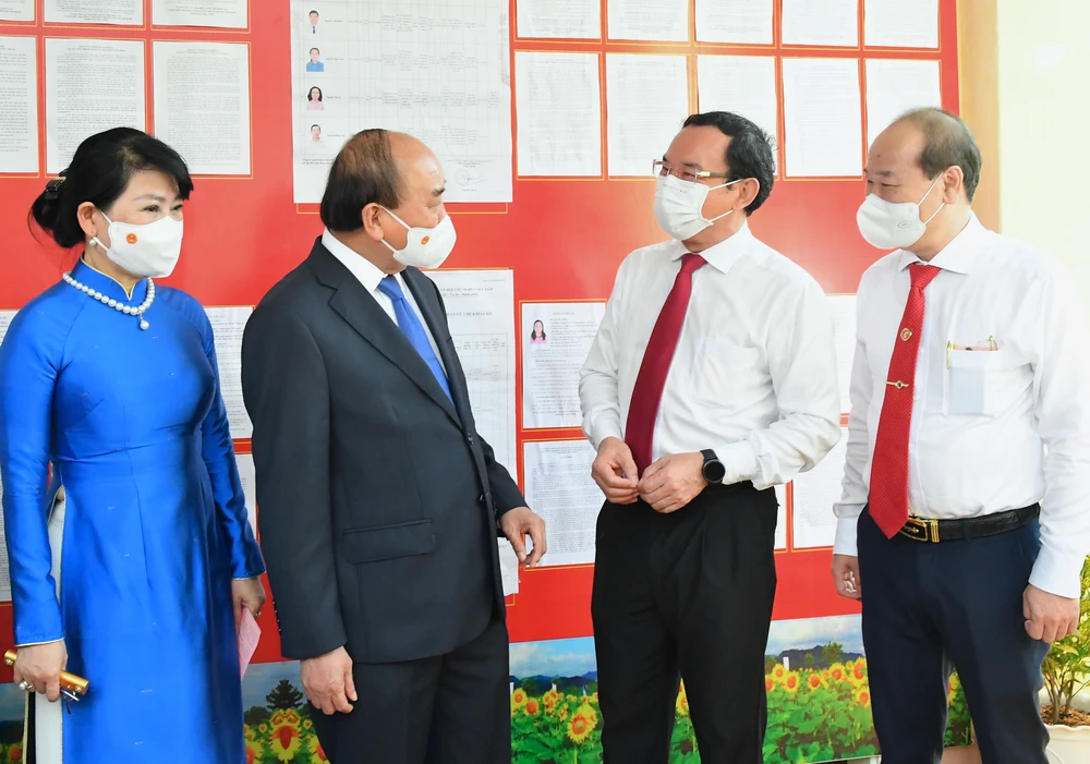 Chủ tịch nước Nguyễn Xuân Phúc trao đổi cùng Bí thư Thành ủy TPHCM Nguyễn Văn Nên sau khi bỏ phiếu. Ảnh: VIỆT DŨNG