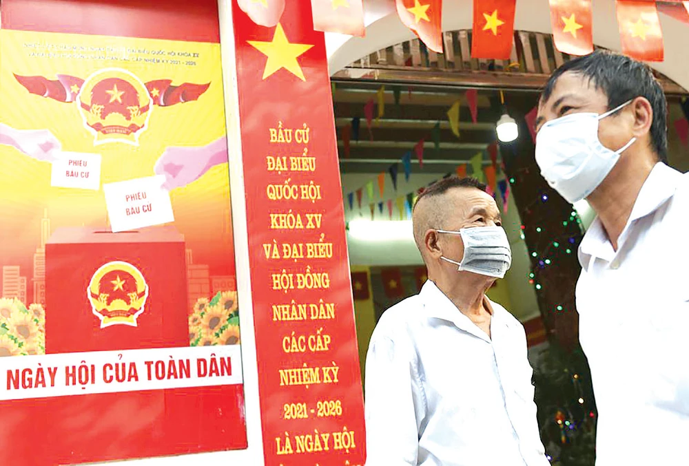 Người dân trước một điểm bỏ phiếu tại Hà Nội. Ảnh: REUTERS