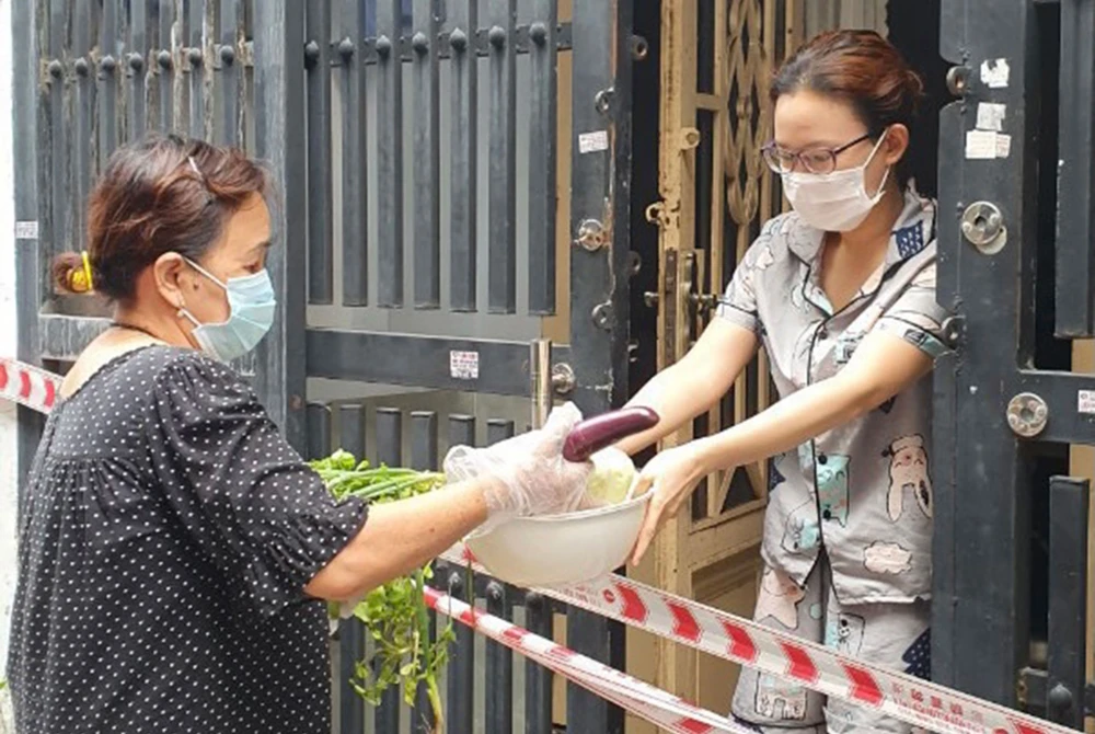 Người dân trong khu phong tỏa tại quận Tân Phú (TPHCM) được chăm lo thực phẩm, an tâm ở nhà phòng chống dịch. Ảnh: THÁI PHƯƠNG
