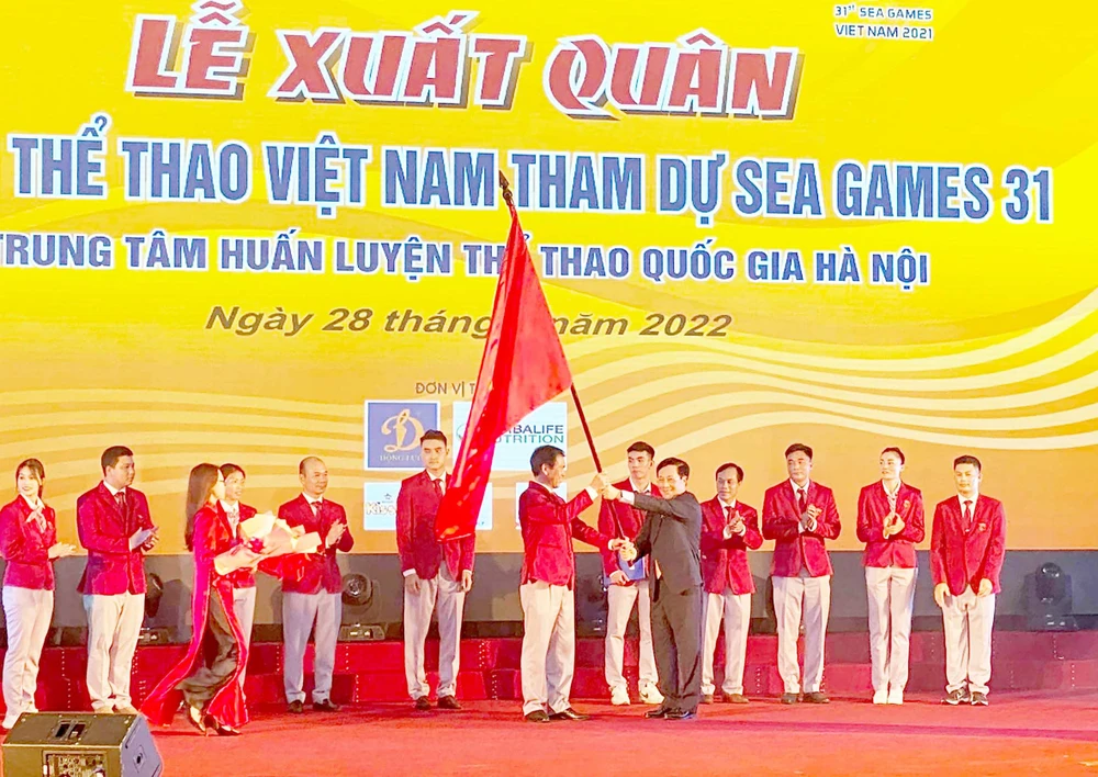 Phó Thủ tướng Thường trực Phạm Bình Minh trao lá quốc kỳ cho Trưởng đoàn Thể thao Việt Nam Trần Đức Phấn. Ảnh: MINH CHIẾN