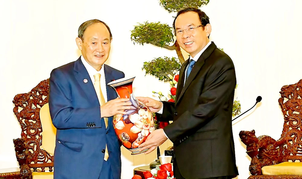 Bí thư Thành ủy TPHCM Nguyễn Văn Nên tặng quà lưu niệm Nguyên Thủ tướng Nhật Bản Suga Yoshihide. Ảnh: VIỆT DŨNG