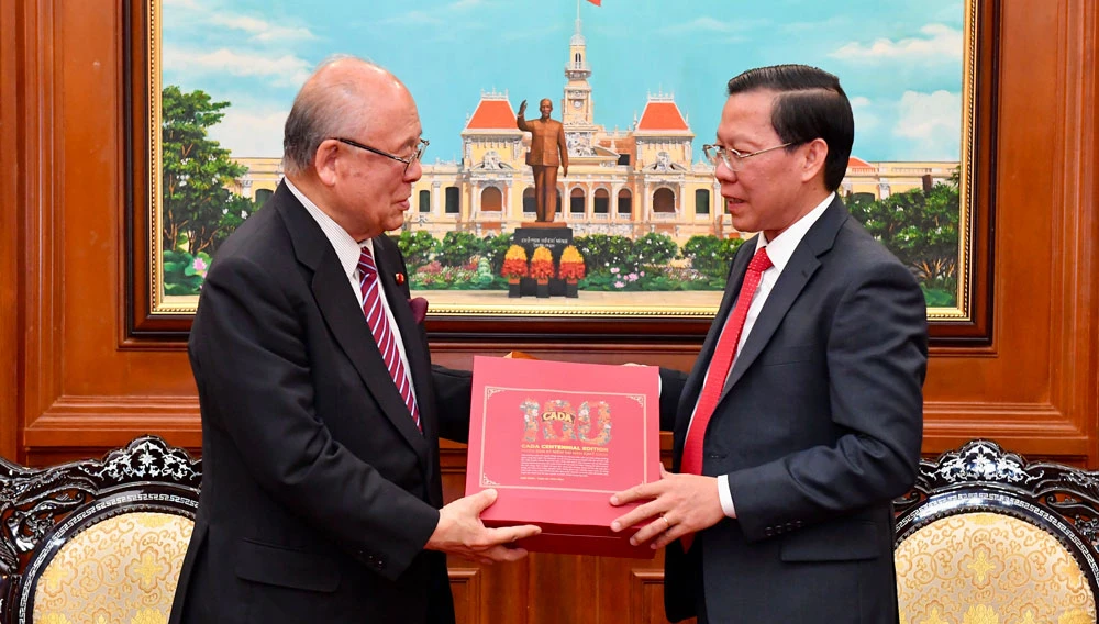 Chủ tịch UBND TPHCM Phan Văn Mãi tặng quà ông Takebe Tsutomu, Cố vấn đặc biệt Liên minh Nghị sĩ Hữu nghị Nhật - Việt. Ảnh: VIỆT DŨNG