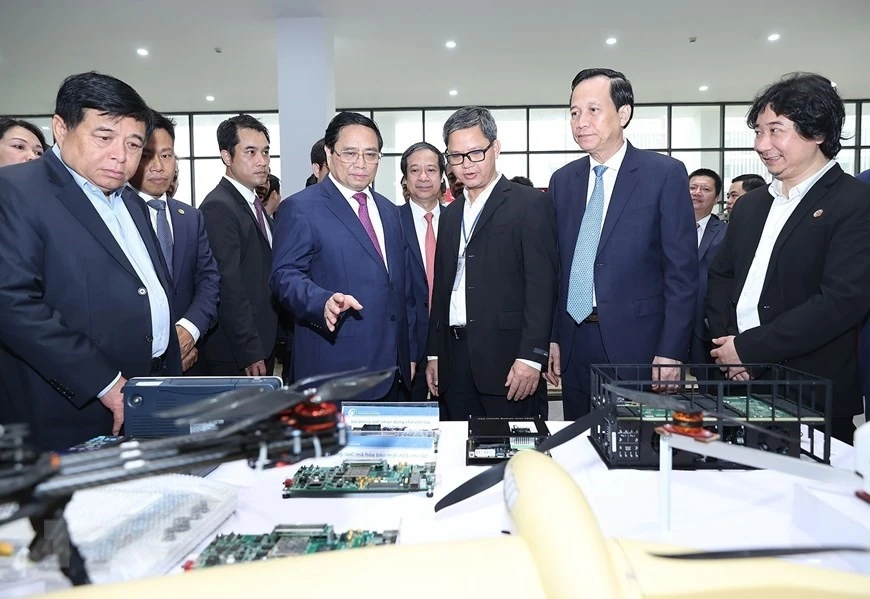 Thủ tướng Phạm Minh Chính tham quan trưng bày các sản phẩm nghiên cứu, chế tạo của Đại học Quốc gia Hà Nội cơ sở Hòa Lạc. Ảnh: TTXVN 