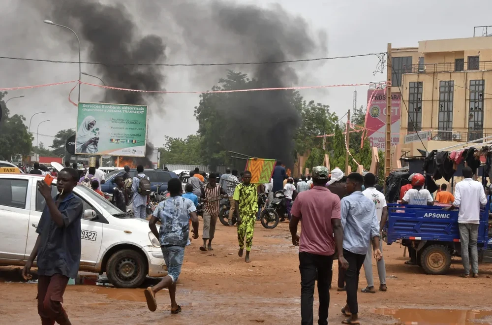 Khói bốc lên hôm 27-7 ở Niamey khi những người ủng hộ lực lượng an ninh Niger tấn công trụ sở của đảng của Tổng thống bị lật đổ Mohamed Bazoum. Ảnh AFP 