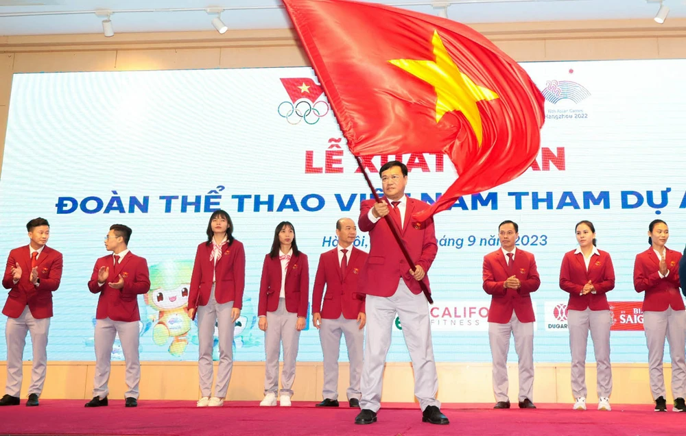 Trưởng đoàn Đặng Hà Việt nhận quốc kỳ cho Đoàn thể thao Việt Nam tại lễ xuất quân tham dự Asiad 19. Ảnh: P.MINH