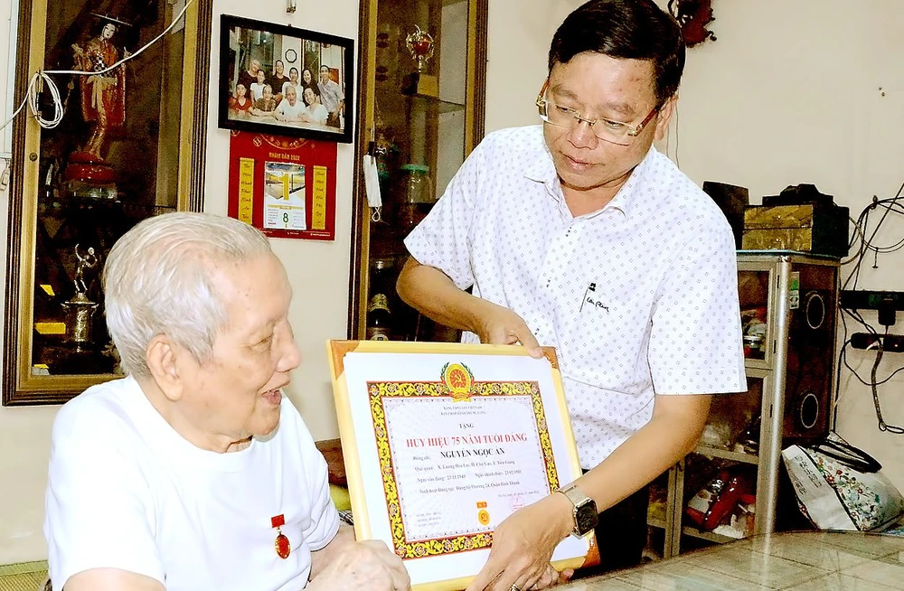 Bí thư Quận ủy quận Bình Thạnh Vũ Ngọc Tuất trao Huy hiệu 75 năm tuổi Đảng tới đồng chí Nguyễn Ngọc Ẩn, năm 2022. Ảnh: HOÀNG ANH