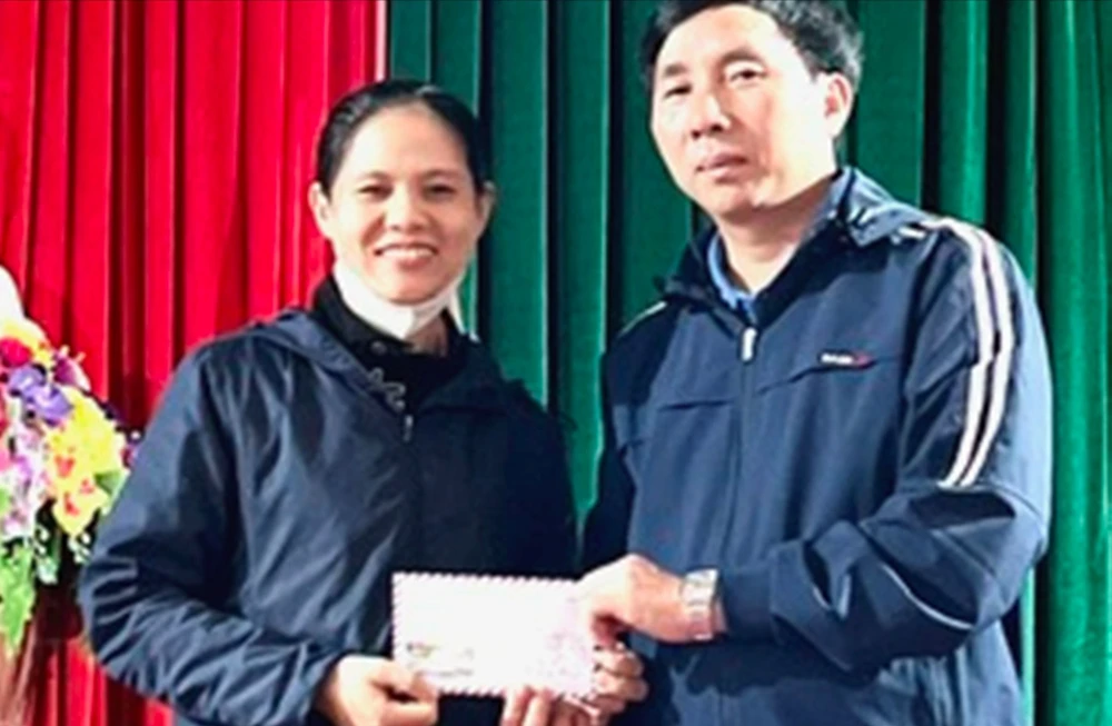 Chị Trần Thị Thành (vợ anh Nguyễn Đình Thiên) tiếp nhận số tiền 13 triệu đồng của bạn đọc Báo SGGP hỗ trợ. Ảnh: DƯƠNG QUANG