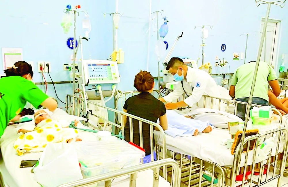 Bác sĩ Bệnh viện Nhi đồng 1, TPHCM thăm khám bệnh nhi mắc sốt xuất huyết. Ảnh: QUANG HUY