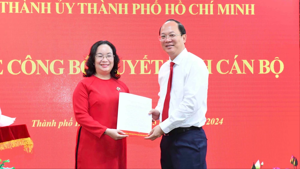 Phó Bí thư Thường trực Thành ủy TPHCM Nguyễn Hồ Hải trao quyết định đến đồng chí Huỳnh Thị Lan Hương. Ảnh: VIỆT DŨNG