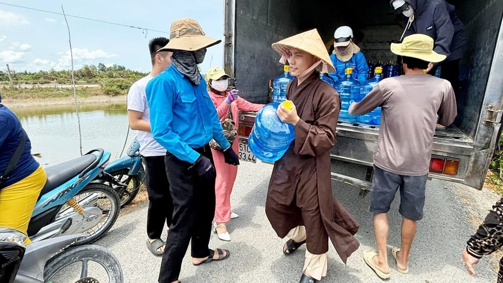 Các sư chùa Hải Quang cùng đoàn thiện nguyện tặng 400 bình nước tại huyện Cần Giuộc, tỉnh Long An. Ảnh: MINH PHƯƠNG