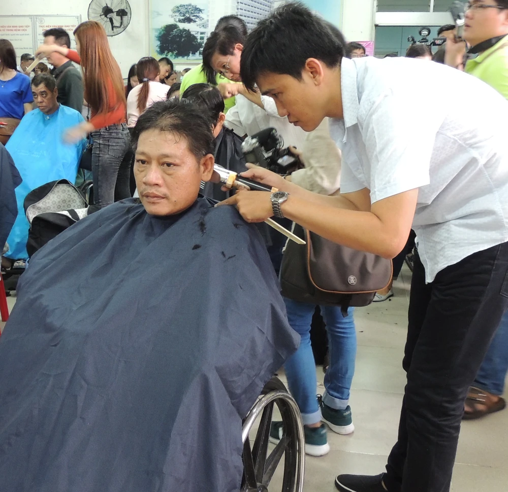 Anh Hàn Văn Thắng được tình nguyện viên cắt tóc. Ảnh: THU HƯỜNG