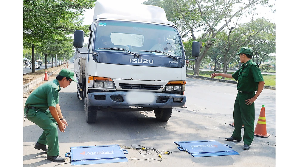 Cân tải trọng xe trên đường Nguyễn Văn Linh, TPHCM. Ảnh: THÀNH TRÍ