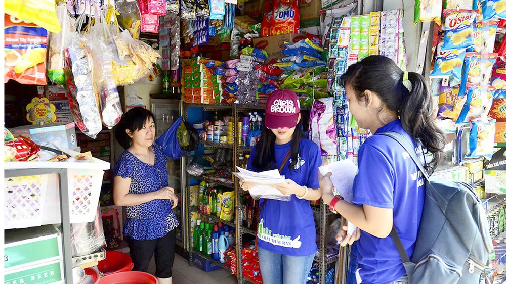 Nhiều người dân tuyến đường Độc Lập (quận Tân Phú) đang được tình nguyện viên hướng dẫn phân loại chất thải rắn tại nguồn