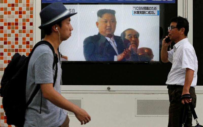 Người dân tại thủ đô Tokyo, Nhật Bản đi ngang qua một màn hình đang phát bản tin về vụ thử hạt nhân của Triều Tiên hôm 3-9. Ảnh: Reuters.