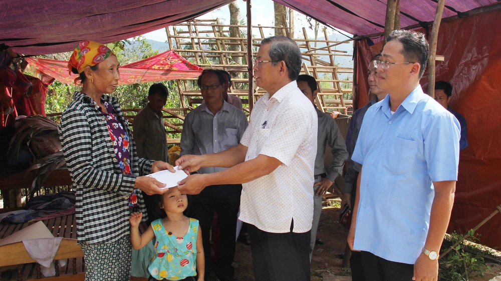Đoàn công tác trao tiền hỗ trợ gia đình bà Đoàn Tiến Lực, thôn Minh Cẩm Ngoại, xã Phong Hóa, huyện Tuyên Hóa dựng lại nhà bị sập. Ảnh: HOÀI NAM