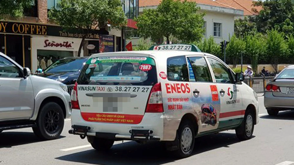Nhiều xe taxi Vinasun ở TPHCM dán biểu ngữ phản đối Uber và Grab 