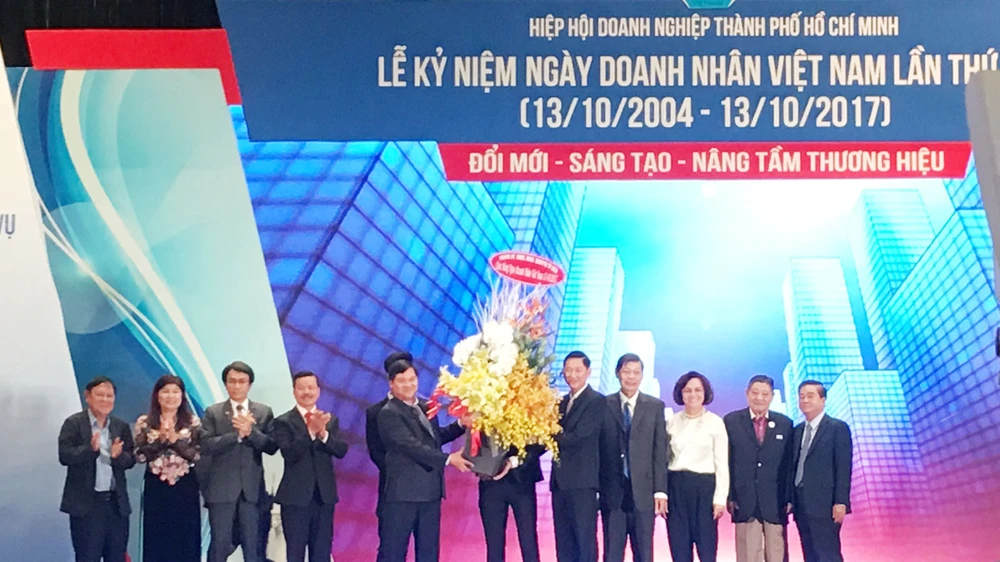 Phó Chủ tịch UBND TPHCM Trần Vĩnh Tuyến tặng lẵng hoa chúc mừng tới các doanh nhân