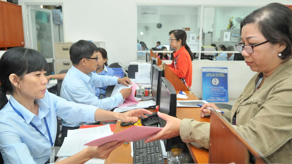 Giải quyết hồ sơ cho người dân tại Công ty cổ phần Cấp nước Gia Định. Ảnh: CAO THĂNG