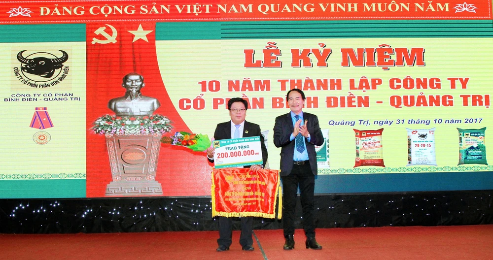TGĐ Công ty CP phân bón Bình Điền (phải) tặng cờ thi đua cho ông Lê Tuấn Dũng (GĐ Cty Bình Điền Quảng Trị). Ảnh: PHAN NAM