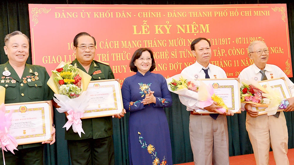 Trưởng ban Tuyên giáo Thành ủy TPHCM Thân Thị Thư trao huy hiệu 40 năm, 45 năm tuổi đảng cho các đồng chí đảng viên. Ảnh: VIỆT DŨNG