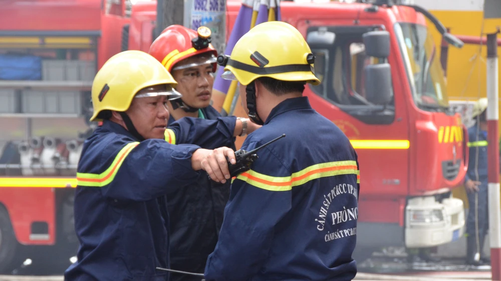 Bất kể giờ giấc nào, đại tá Lê Tấn Bửu (bìa trái) cũng thường xuyên có mặt tại hiện trường trực tiếp chỉ huy các chiến sĩ chữa cháy 