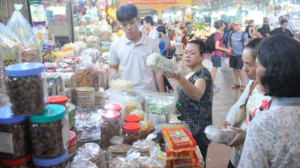 Người tiêu dùng chọn mua kẹo mứt tết tại chợ Bến Thành. Ảnh: CAO THĂNG
