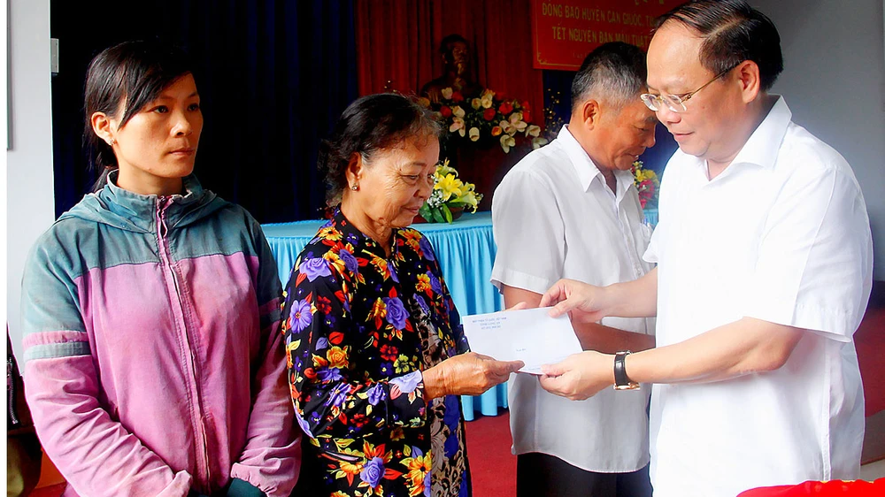 Đồng chí Tất Thành Cang, Phó Bí thư Thường trực Thành ủy TPHCM, thăm và tặng quà tết cho người dân hoàn cảnh khó khăn Ảnh: PHẠM MINH
