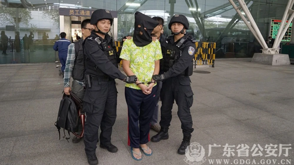 Cảnh sát đặc nhiệm áp giải một ngi phạm bị bắt ở tỉnh Quảng Đông. Ảnh do Cảnh sát Quảng Đông công bố ​