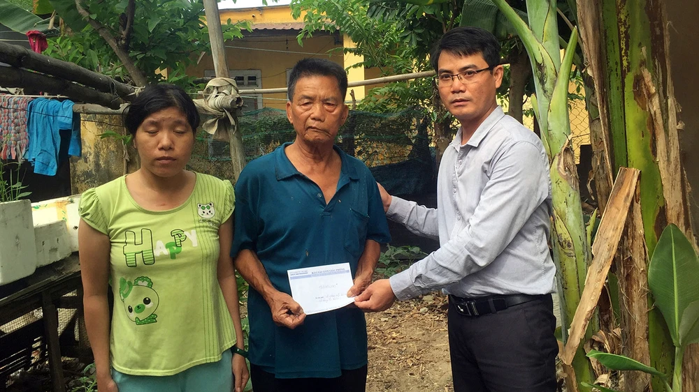 Đại diện Báo SGGP trao tiền hỗ trợ gia đình chị Nhất, anh Sinh