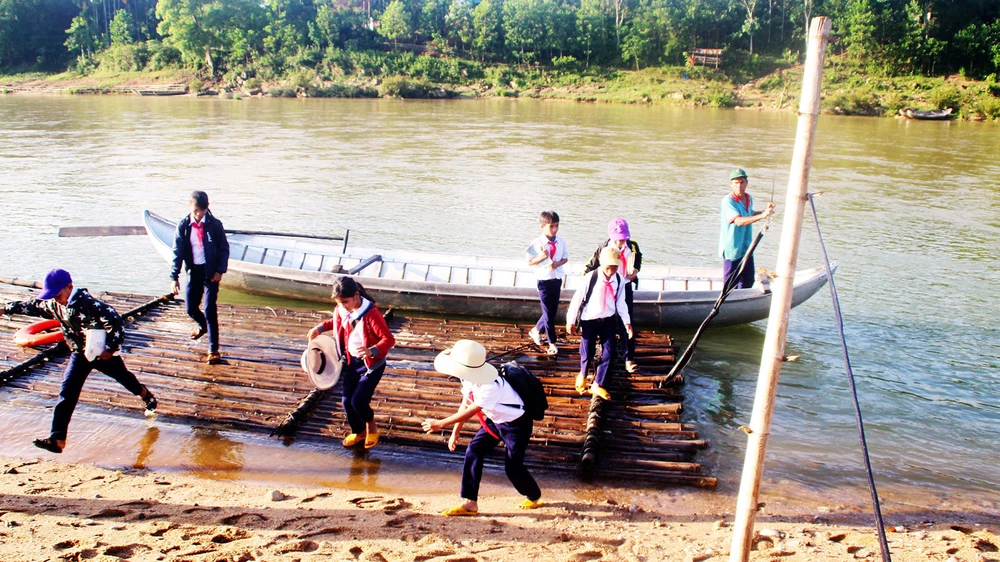 Ông Đinh K’Rắt đưa học sinh ở bản Nước Rinh qua sông Rinh “tìm con chữ” suốt 15 năm qua