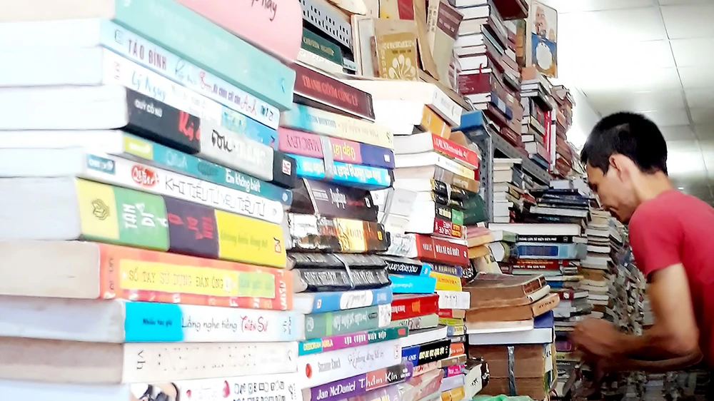 Những chồng sách cao ngất, chất kín lối, nằm im lìm trong các quầy sách tại phố sách cũ Trần Nhân Tôn (quận 5)
