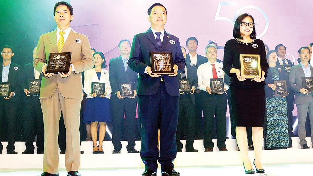 Ông Lê Viết Hải - Chủ tịch HĐQT, Tổng Giám đốc Công ty Cổ phần Tập đoàn Xây dựng Hòa Bình (đứng giữa) nhận bảng vàng chứng nhận tại buổi lễ tôn vinh 