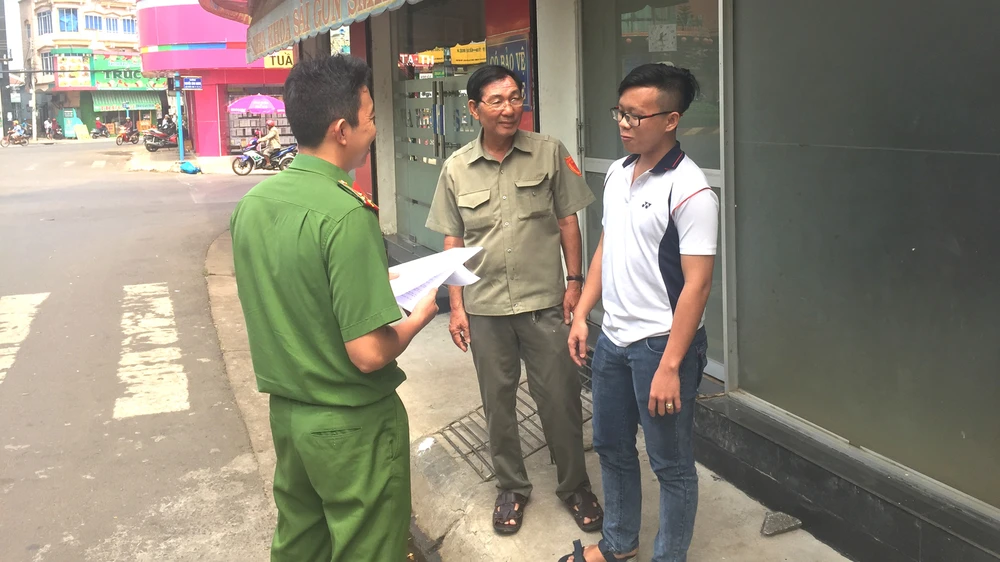 Ông Nguyễn Văn Ba (giữa) cùng Công an phường Xuân An tuyên truyền phòng chống tội phạm cho một cơ sở kinh doanh trên địa bàn