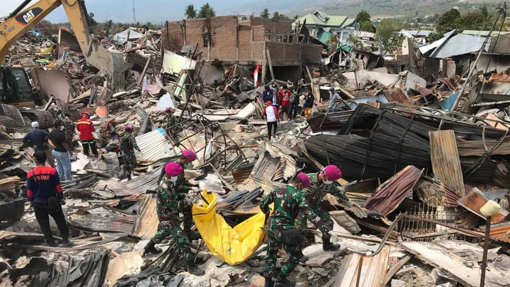 Lực lượng chức năng Indonesia đang nỗ lực tìm kiếm những người sống sót trong đống đổ nát. Ảnh: EPA