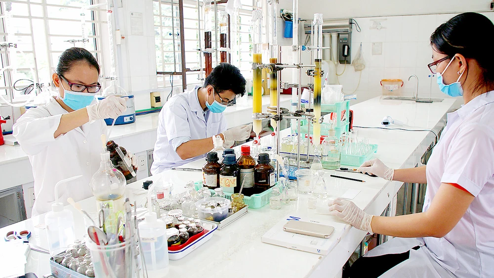 Sinh viên Trường Đại học Sài Gòn nghiên cứu hóa học tạo vi sinh bảo vệ môi trường. Ảnh: HOÀNG HÙNG