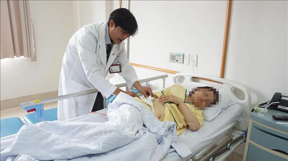 Bệnh nhân Nguyễn Thị Như T được bác sĩ kiểm tra tình hình sức khỏe trước khi xuất viện