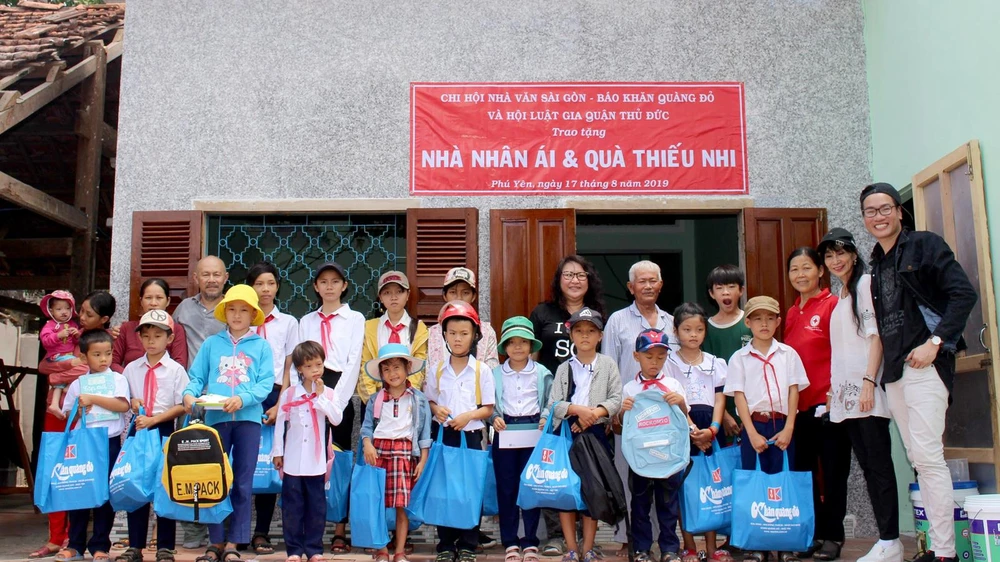 Các thành viên Chi hội Nhà văn Sài Gòn và những học sinh nghèo, hiếu học cùng ông Nguyễn Ngọc Anh trước ngôi nhà nhân ái vừa được trao